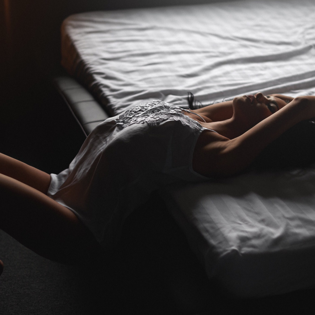 Женское тело в темноте в кровати