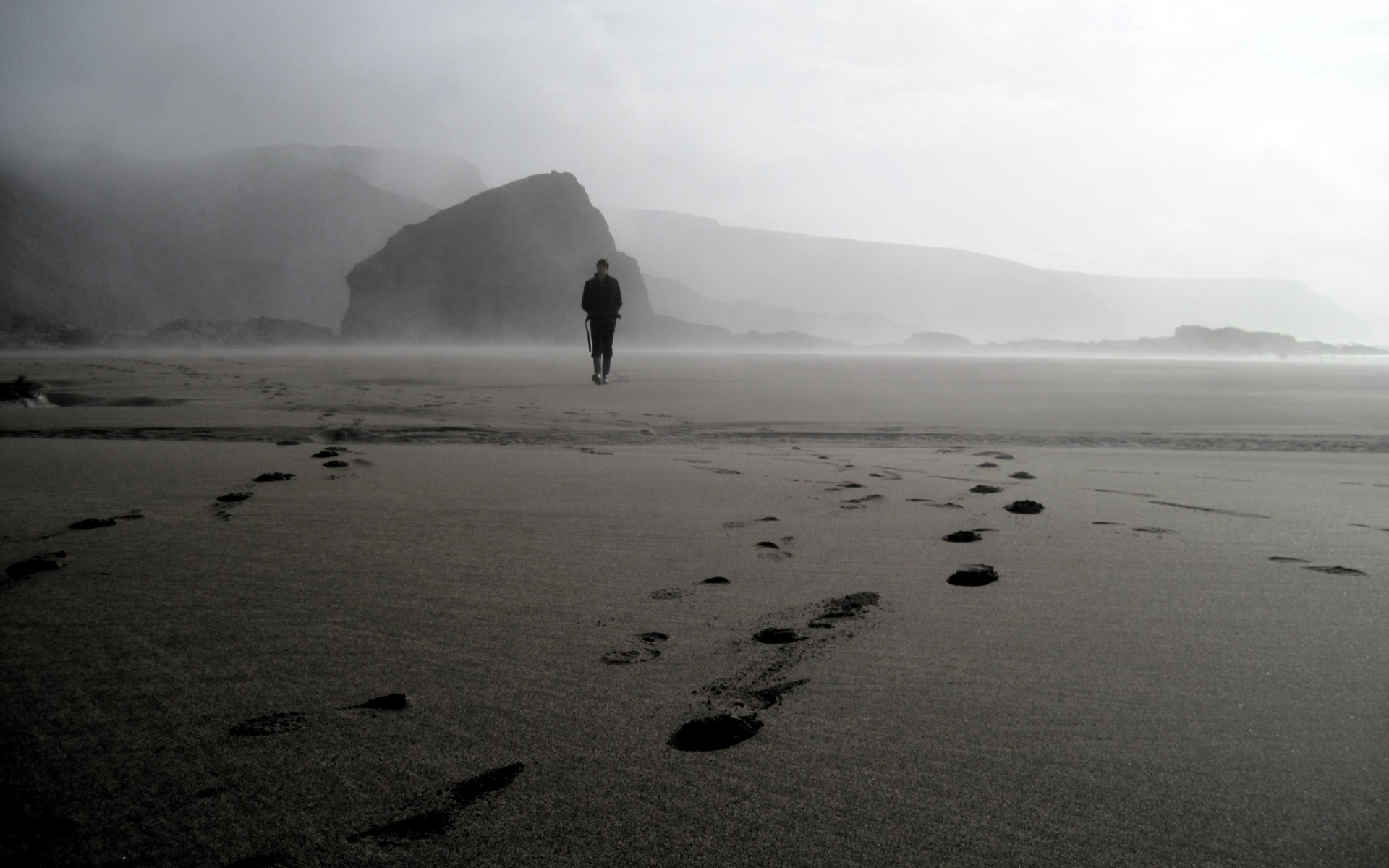 Есть я у мужа у камня. Море в тумане. Человек на берегу туман. Пляж в тумане. Туманный пляж.