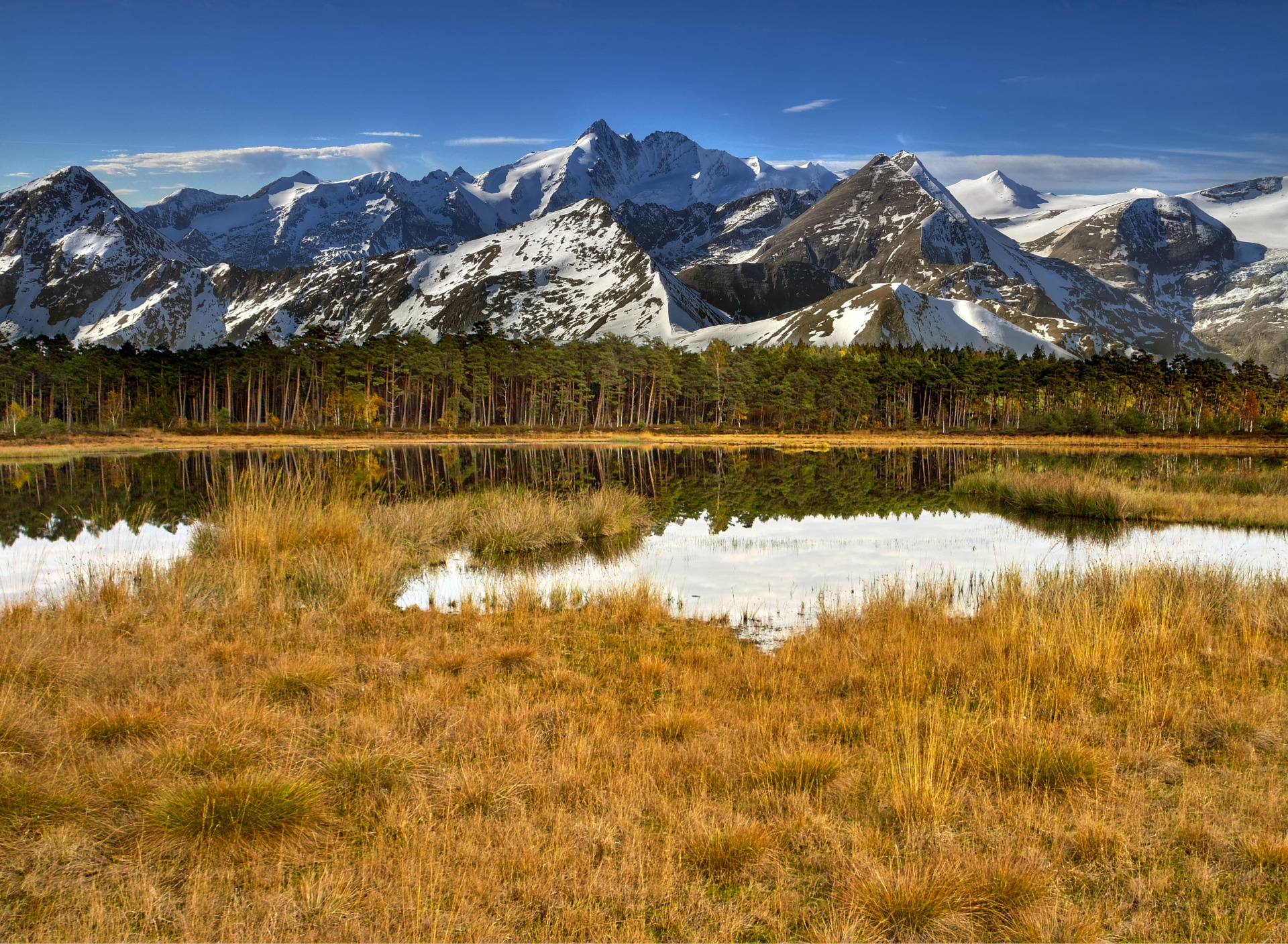 Snow capped mountains. Панорама природа. Горы снег трава озеро. Горы снег вода трава. Обои горы вода трава.