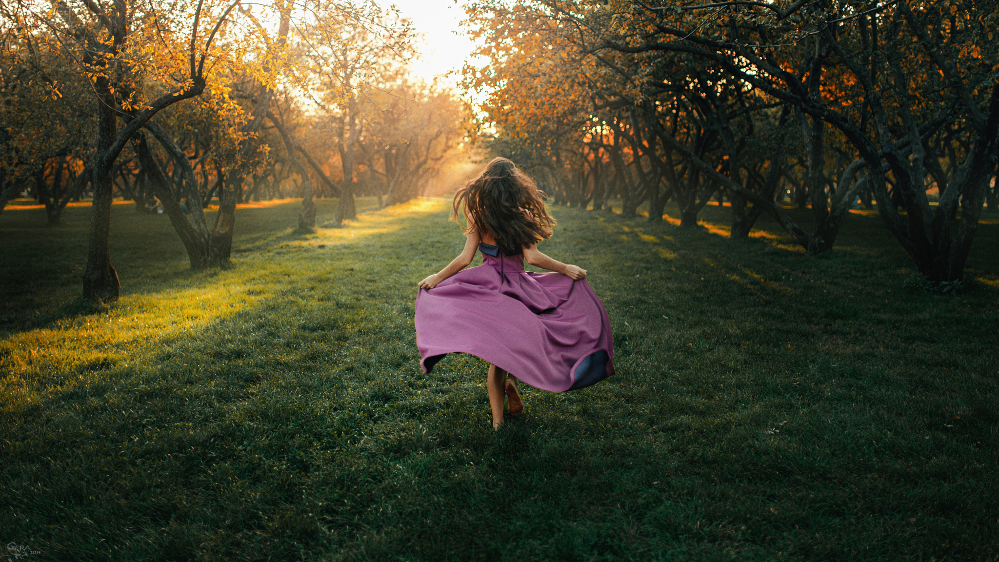 В саду гуляет ветер. Девушка убегает. Девушка бежит в платье. Девушка в платье убегает. Девушка на природе со спины.