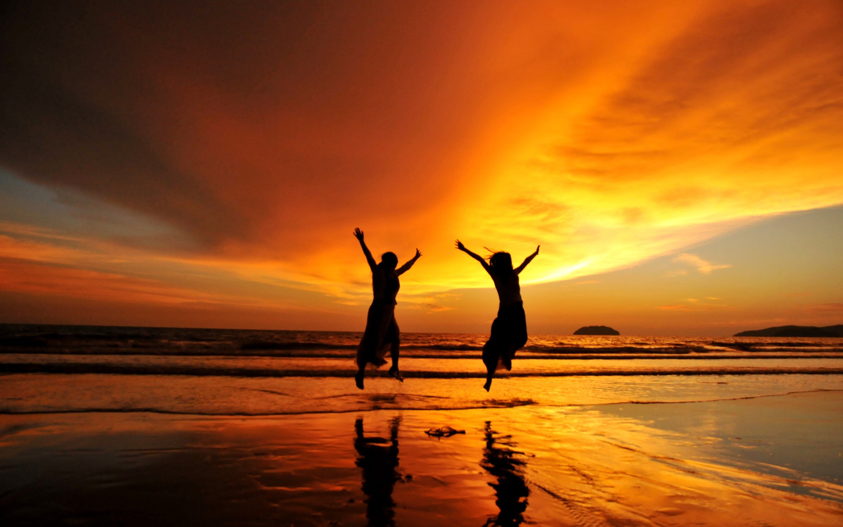 Радоваться рассвету. Закат солнца. Счастливые люди на закате. Двое людей на закате. Пляж на закате с людьми.