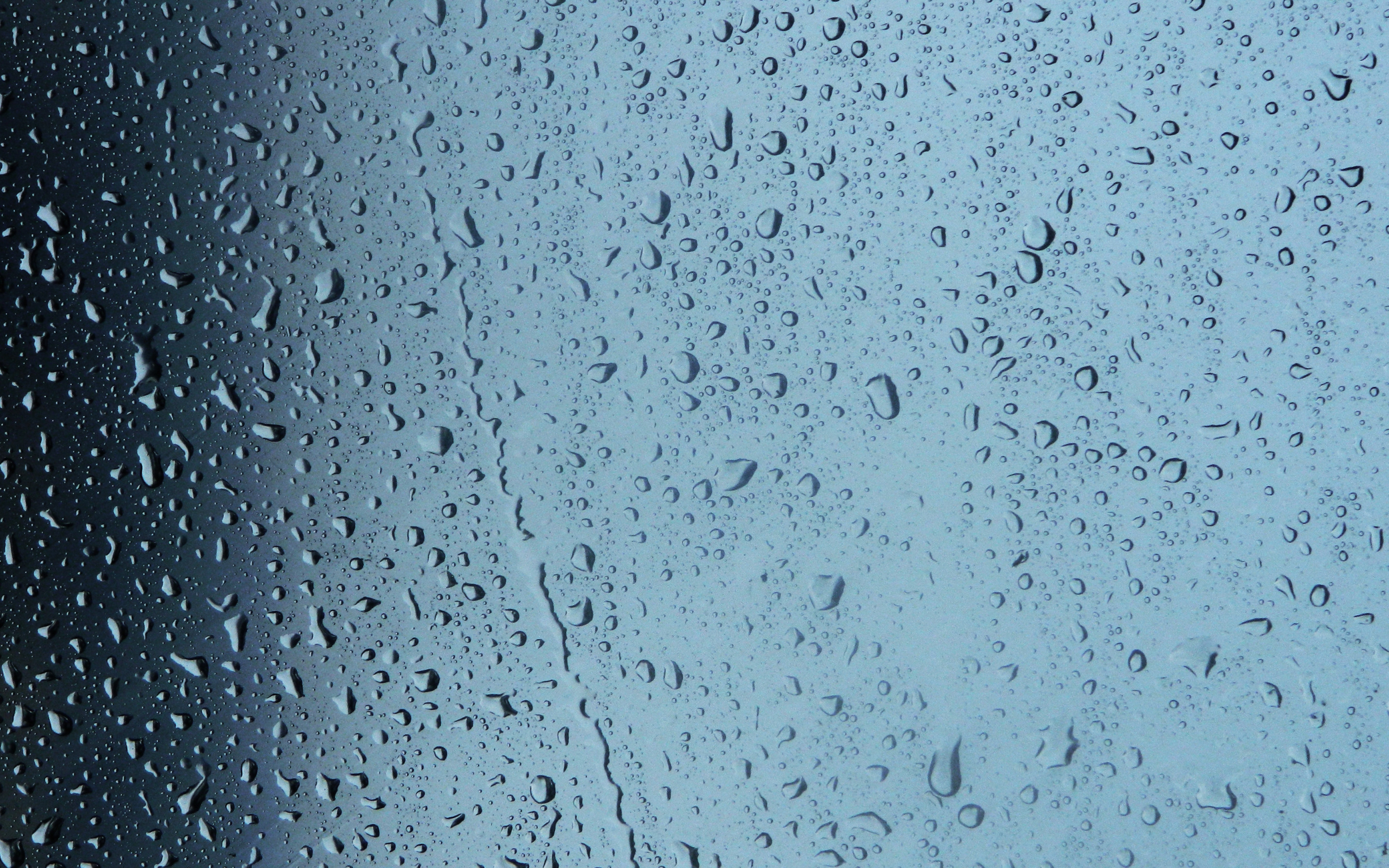 В стене капает вода. Капли на стекле. Мокрое стекло. Капли дождя на стекле. Стекло текстура.