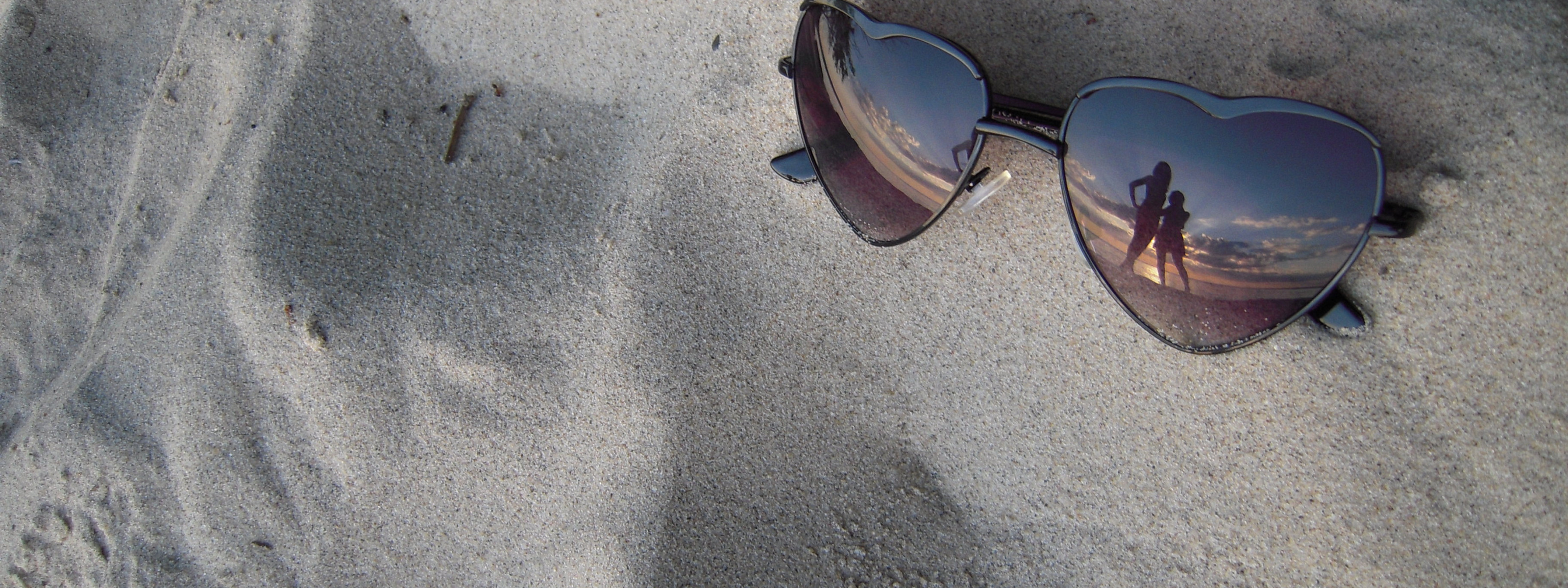 Разбитое очко. Солнечные очки на песке. Сломанные солнечные очки. В очках отражается море. Разбитые очки.
