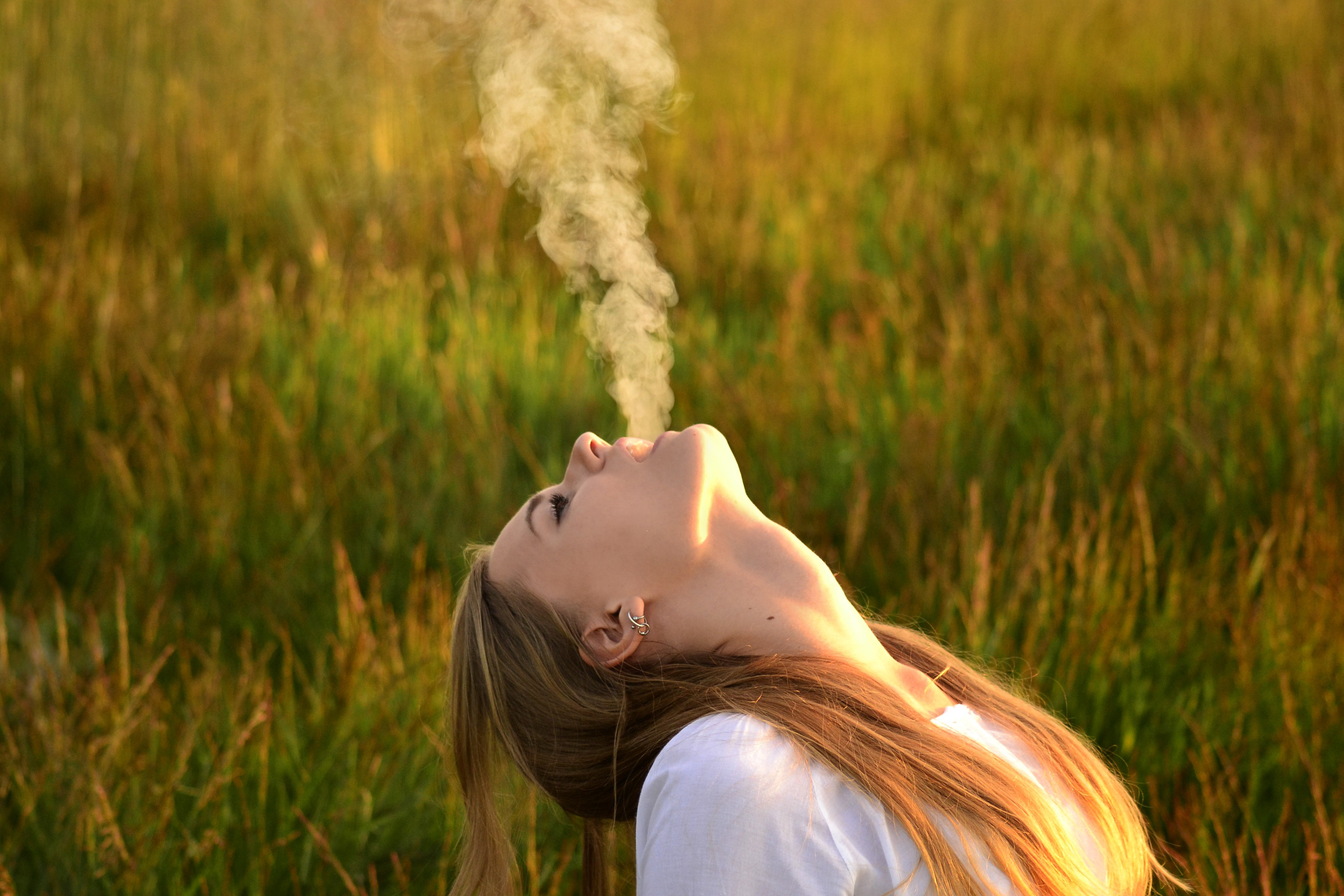 В поле дым бьют по молодым песня. Женщина с запрокинутой головой. Девушка выдыхает. Выдыхает дым. Девушка в дыму.