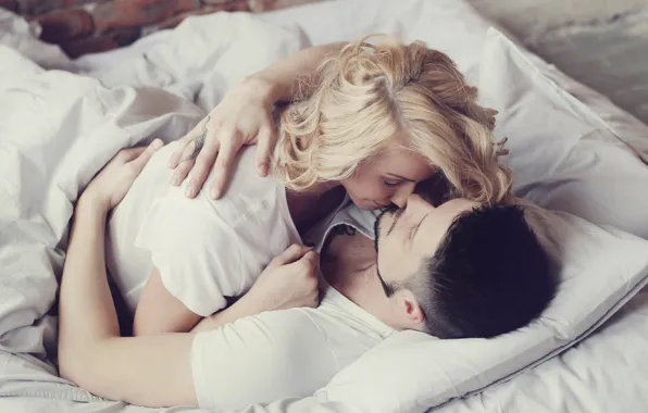 Стоковые фотографии Пара Поцелуи И Объятия На Кровати В Спальне премиум-класса