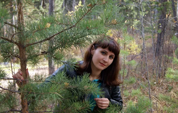 Девушка, брюнетка, в лесу, выглядывает из-за сосенки