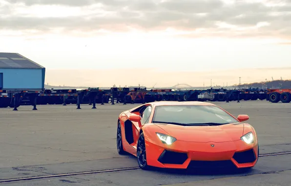 Обои небо, облака, оранжевый, здание, lamborghini, вид спереди, orange ...