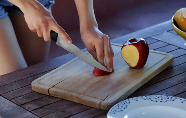 Apple, hands, knife, cutting board, wood table, slicing fruit