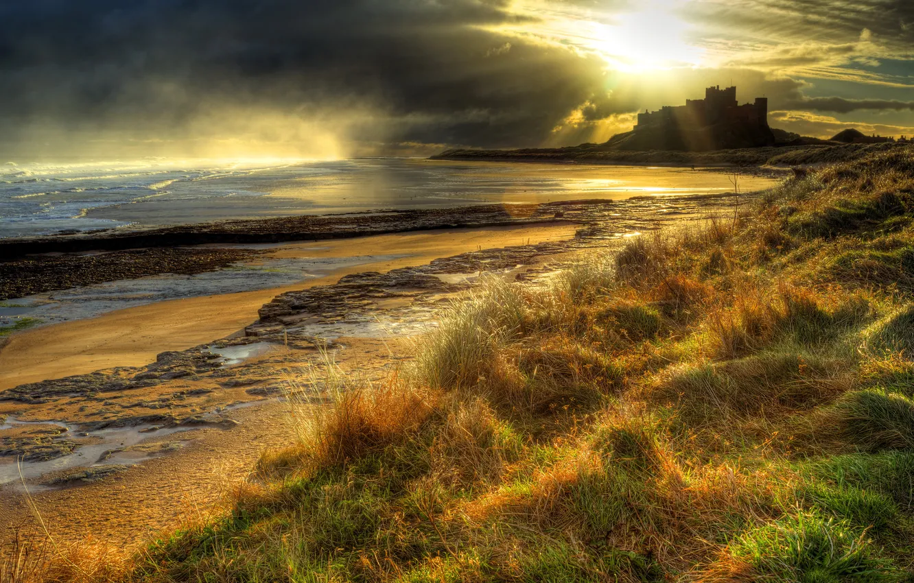 Фото обои море, небо, трава, закат, тучи, камни, замок, побережье
