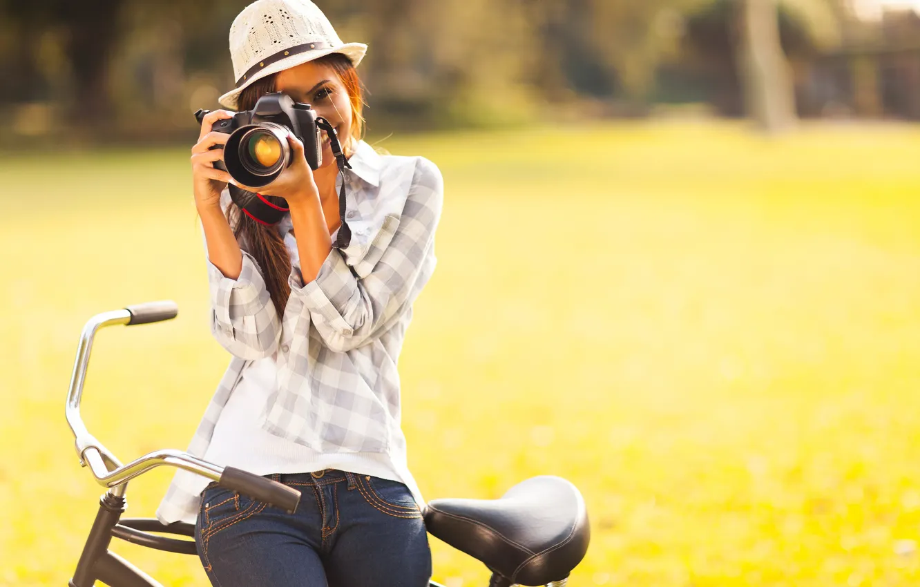Фото обои зелень, девушка, велосипед, улыбка, шляпа, фотоаппарат, шатенка