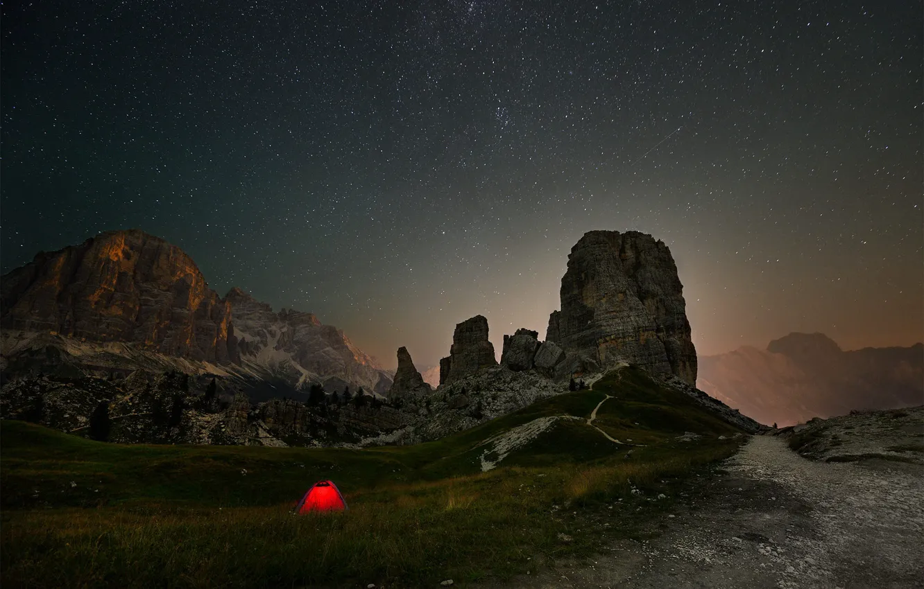 Фото обои дорога, трава, звезды, свет, горы, ночь, скалы, вершины