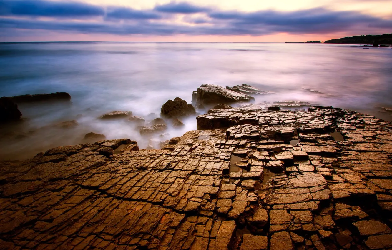 Фото обои море, поверхность, тучи, трещины, камни, вечер