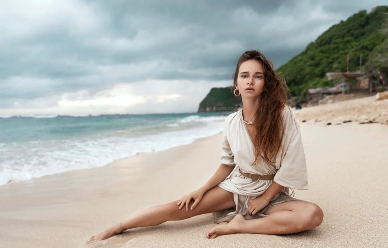 Фото обои песок, пляж, взгляд, девушка, поза, океан, ноги, волосы
