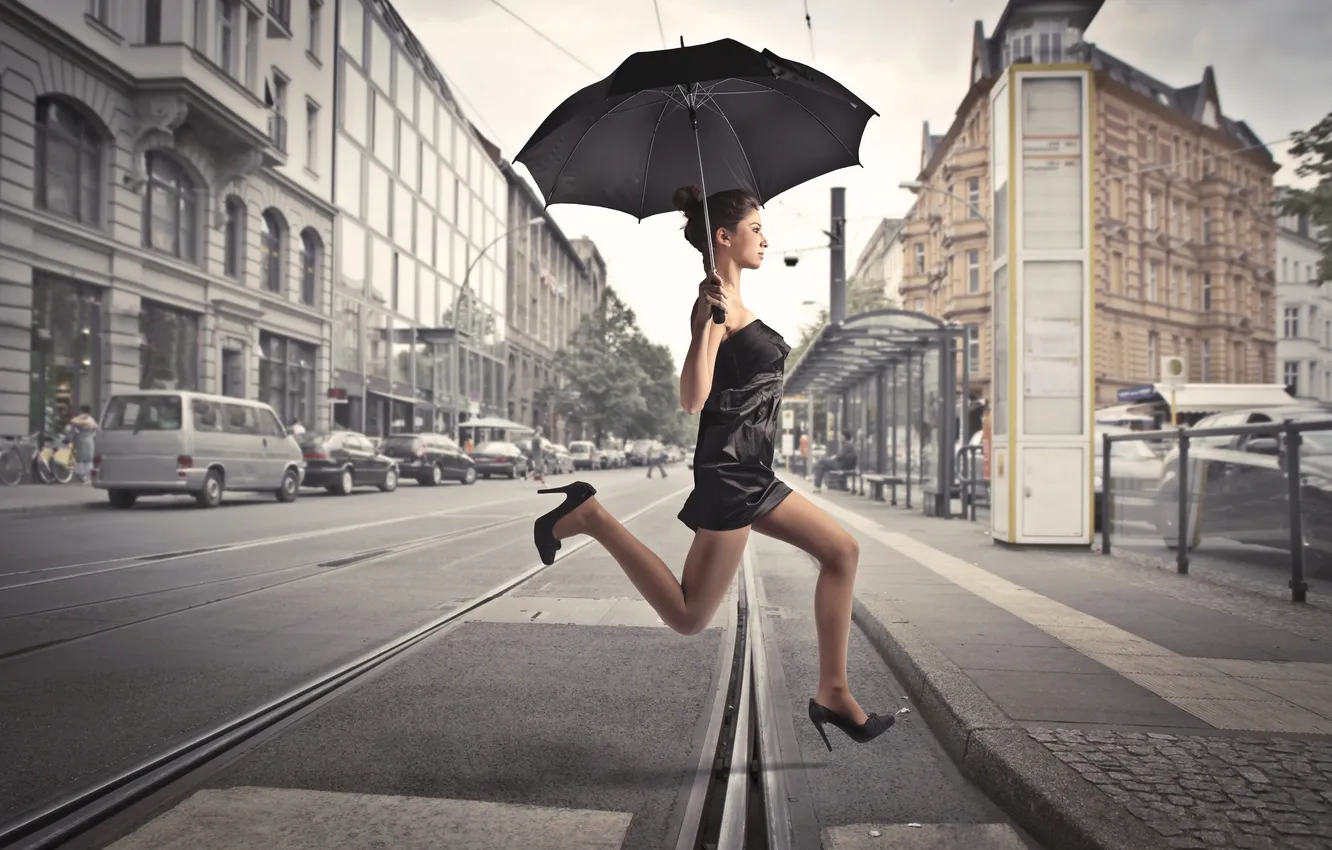 Фото обои девушка, машины, город, прыжок, здания, рельсы, зонт, остановка