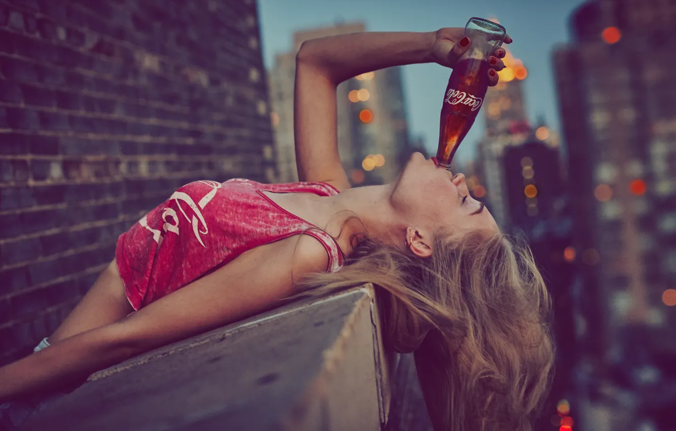 Фото обои девушка, наслаждение, небоскребы, напиток, coca cola, кока-кола, кирпичная стена, закрытые глаза