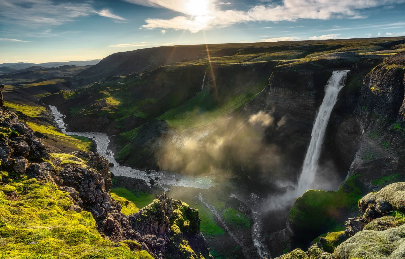 Фото обои небо, солнце, облака, река, камни, скалы, водопад, Исландия