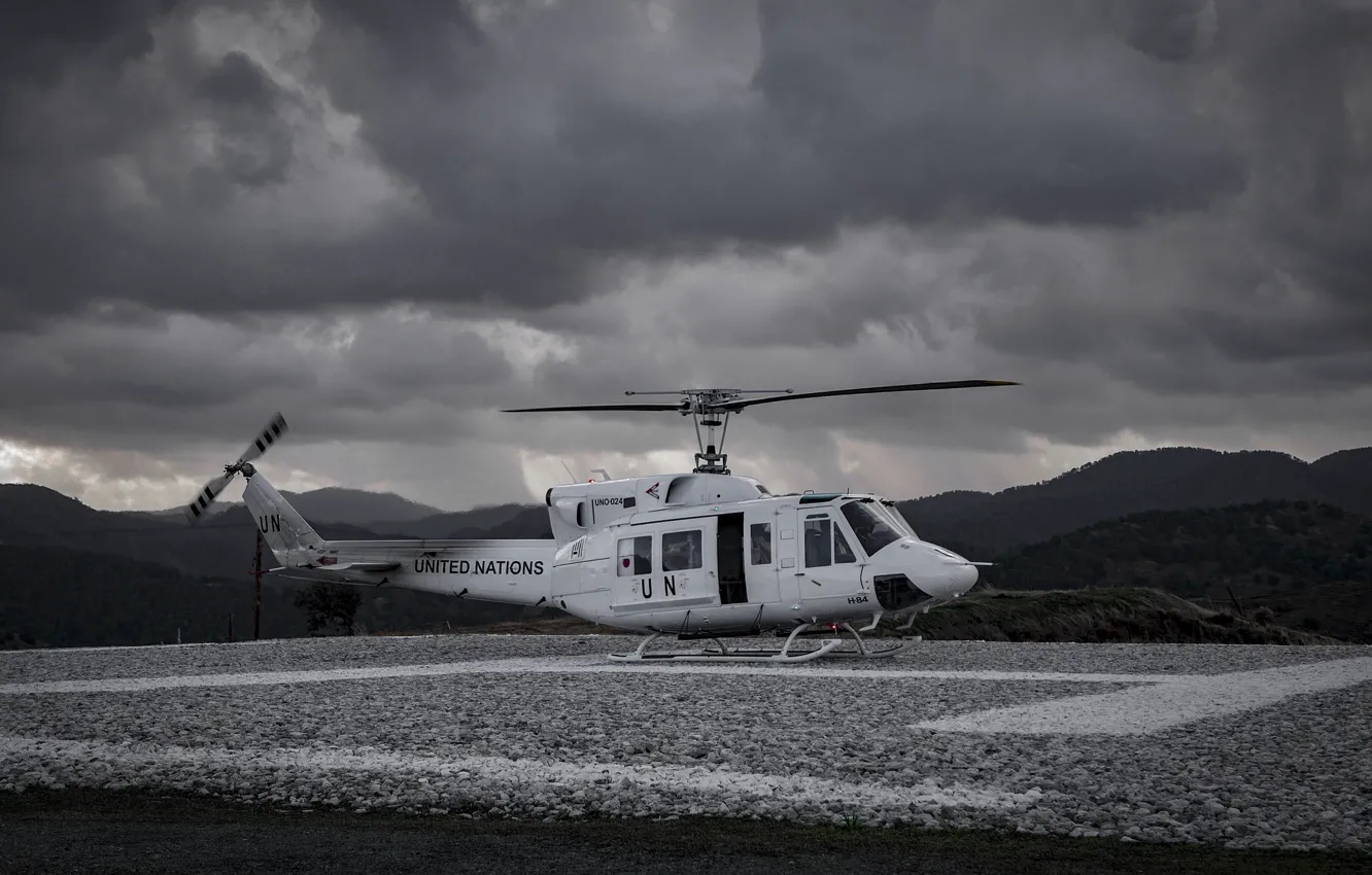 Фото обои тучи, вертолет, ООН, посадочная площадка, Bell UH-1 Iroquois