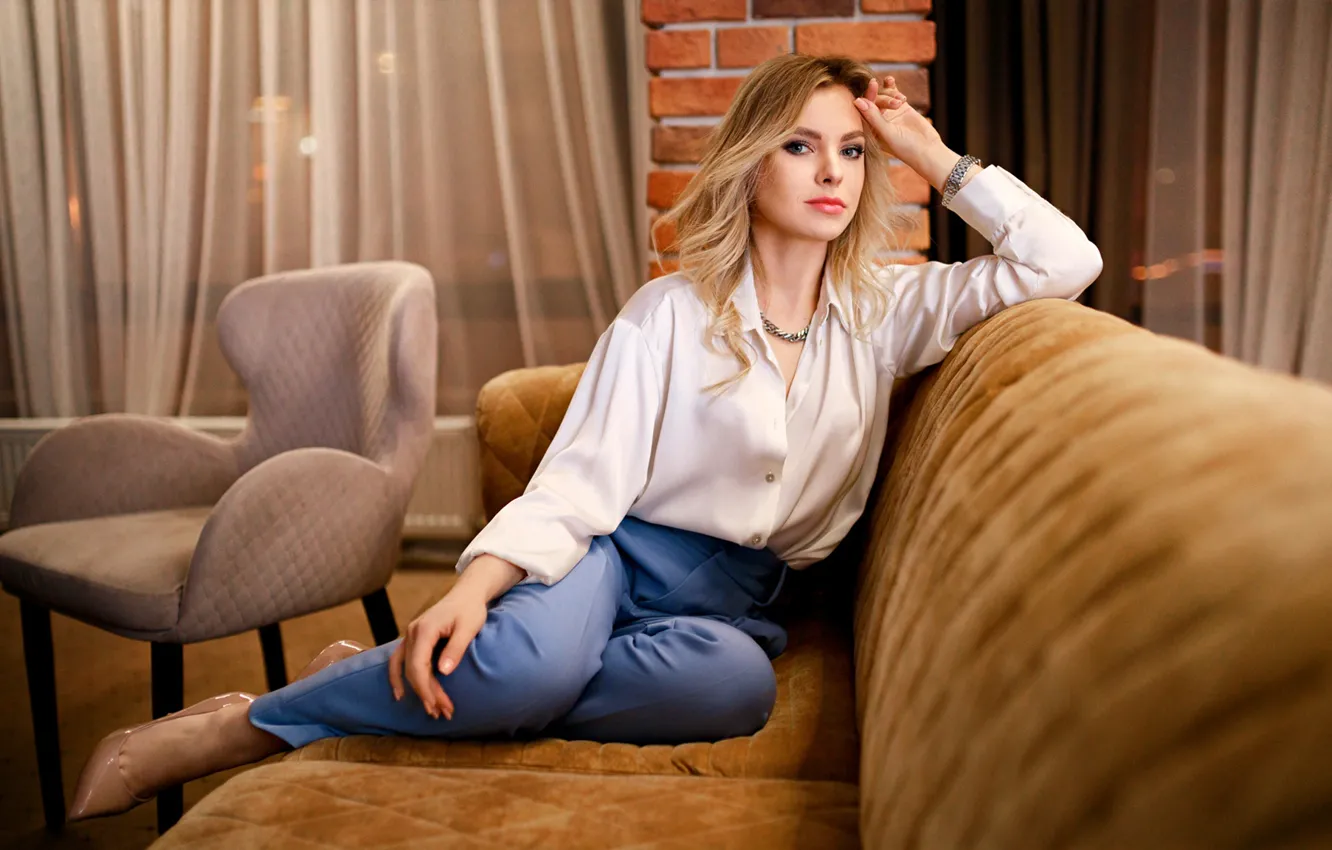 блондинка сидит на диване