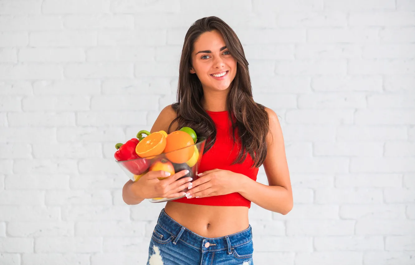 Фото обои взгляд, девушка, красный, поза, улыбка, стена, лимон, яблоки