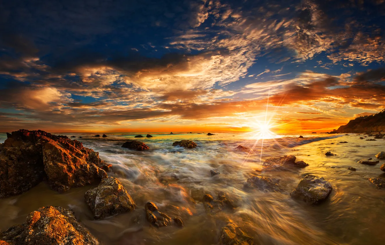 Фото обои море, небо, солнце, облака, лучи, камни, рассвет, побережье