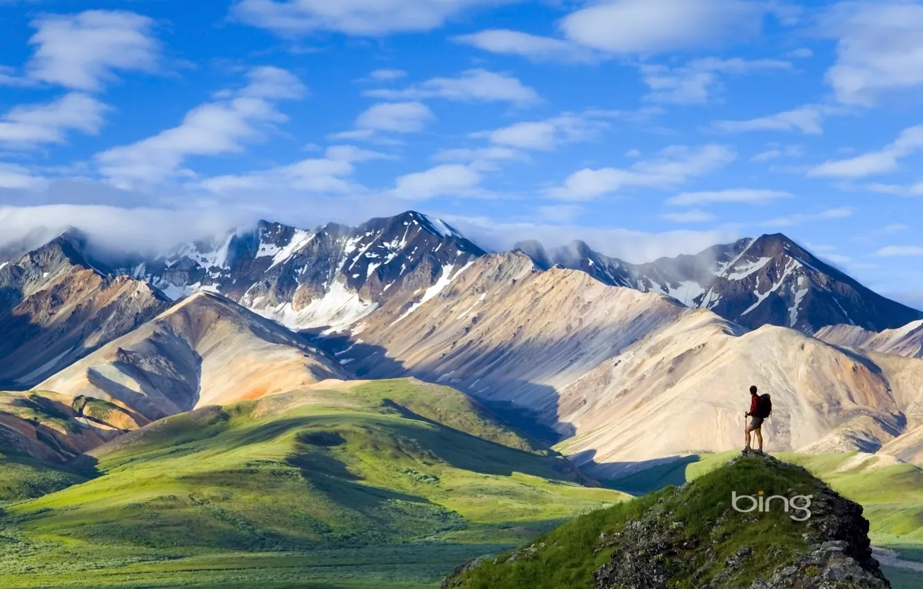 Фото обои небо, трава, облака, снег, горы, путешественник, вершина, рюкзак