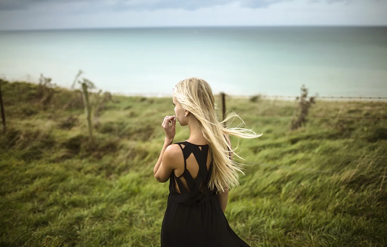 Фото обои трава, ветер, спина, платье, черное, блондинка, вырез
