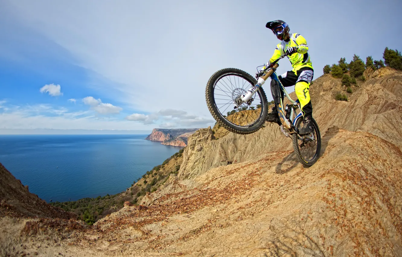 Фото обои море, горы, велосипед, скалы, побережье, костюм, перчатки, шлем