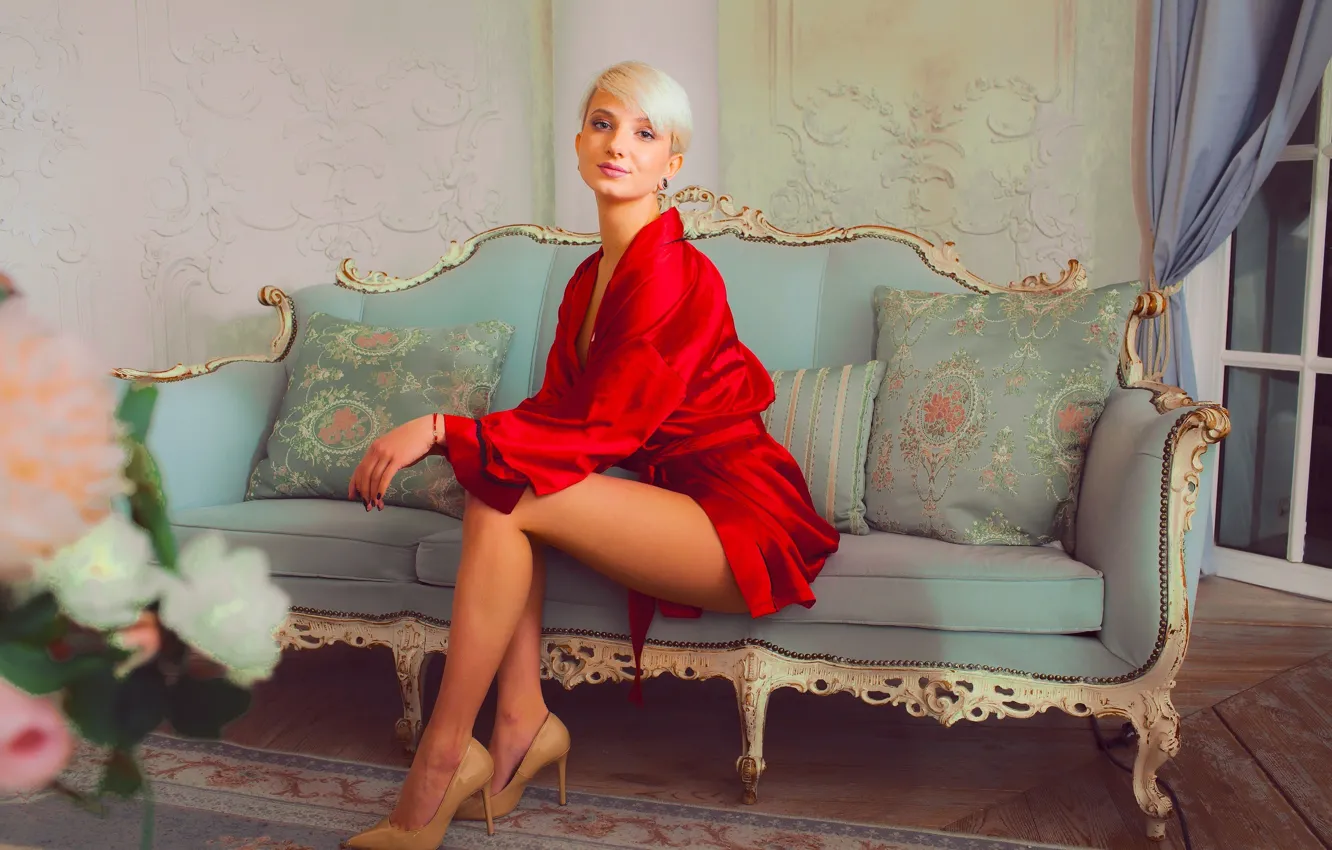 Блондинка в чулках на красном диване
