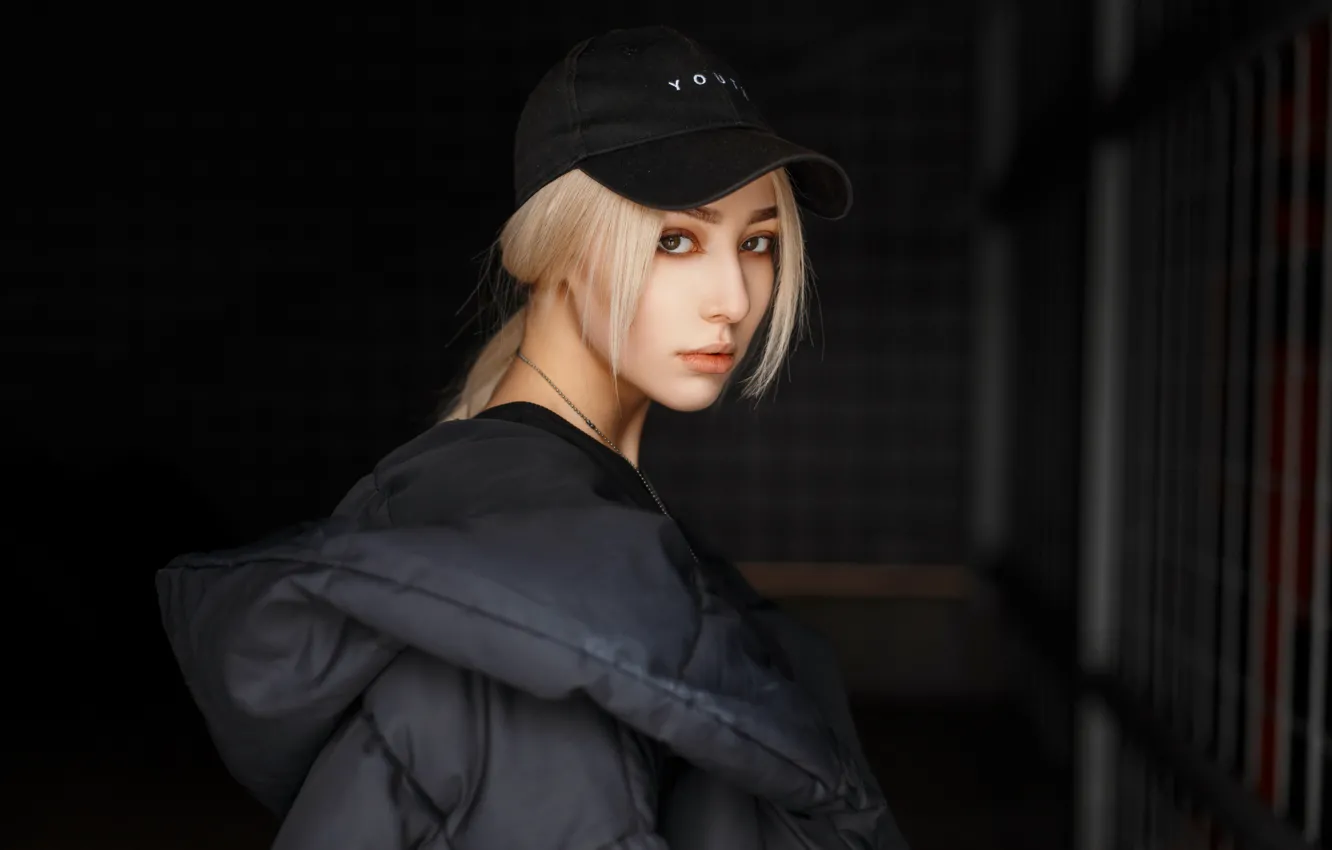 Фото обои girl, beauty, hair, look, blonde, dark background, baseball cap, feather jacket