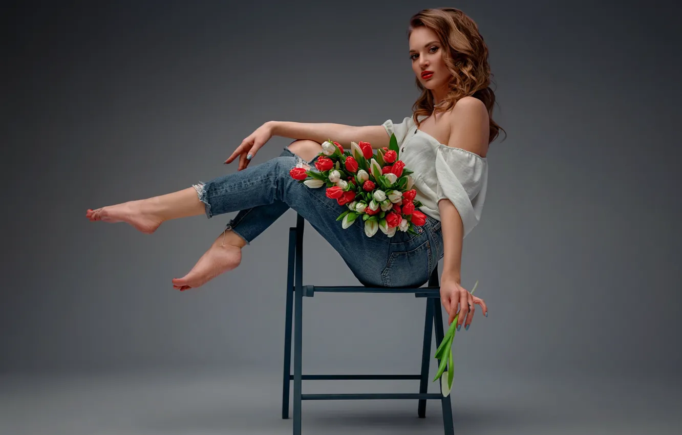 Фото обои девушка, цветы, поза, фон, ноги, джинсы, тюльпаны, плечо