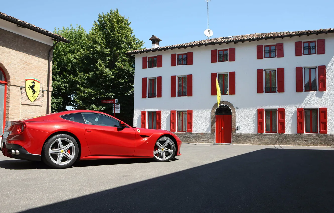 Фото обои красный, здание, суперкар, вид сбоку, ferrari f12 berlinetta