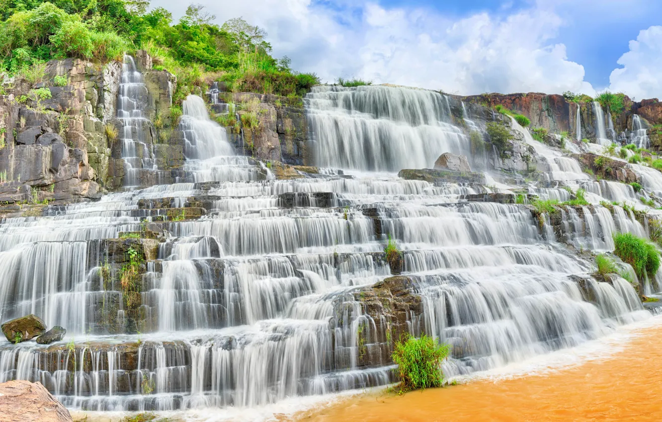 Фото обои зелень, небо, трава, солнце, облака, камни, скалы, водопад