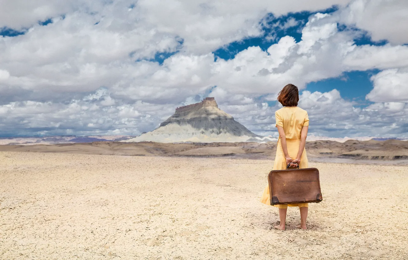 Фото обои песок, небо, девушка, облака, пустыня, гора, платье, чемодан