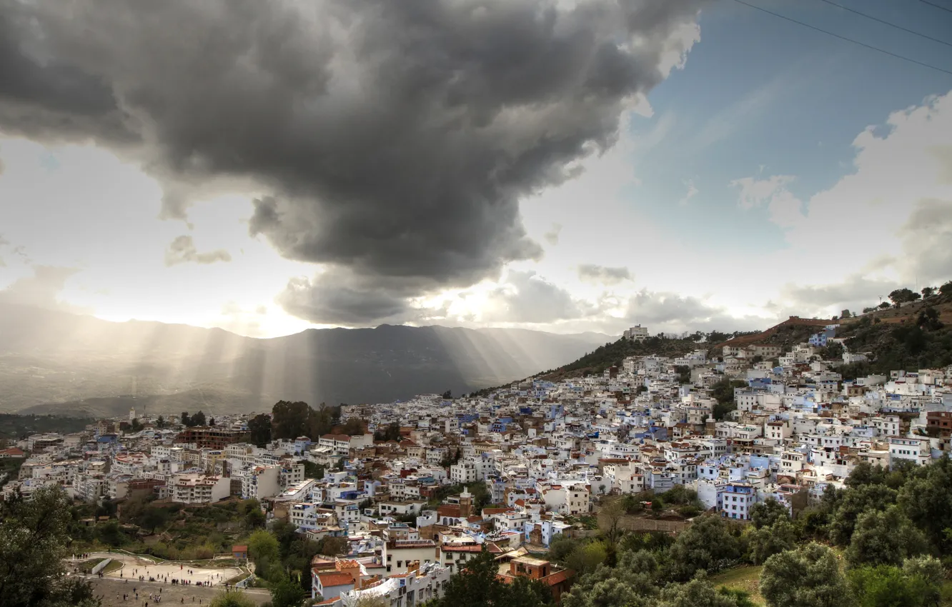 Фото обои небо, облака, деревья, горы, дома, панорама, лучи солнца, Марокко
