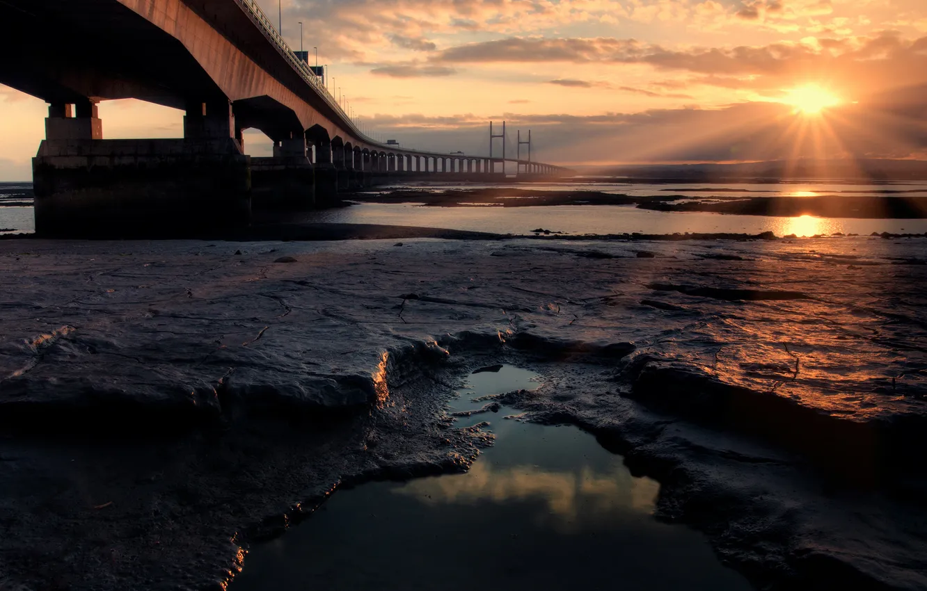 Фото обои море, солнце, лучи, мост, камни, океан, берег